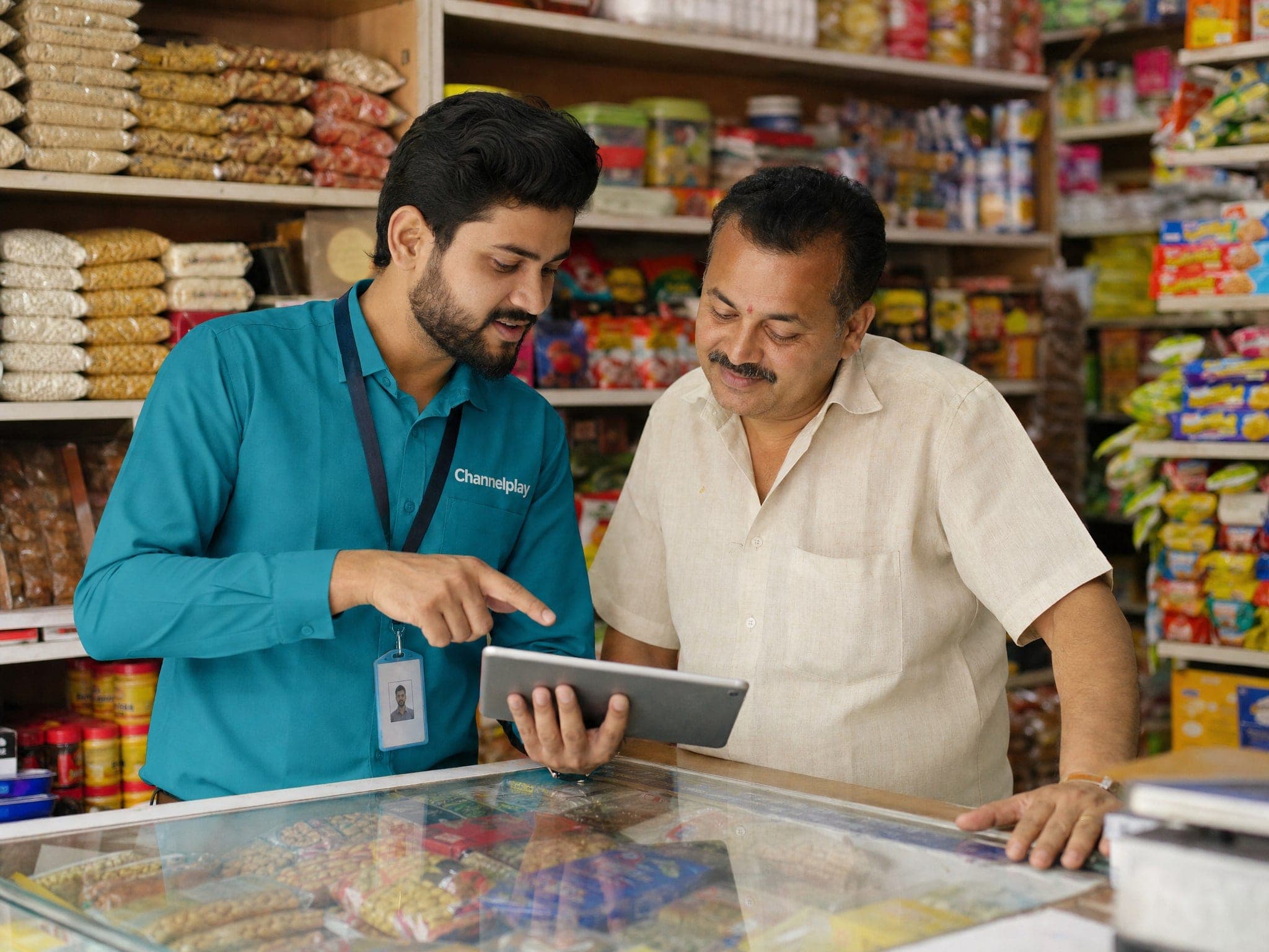 Channelplay field executive onboarding a merchant at a kirana store counter